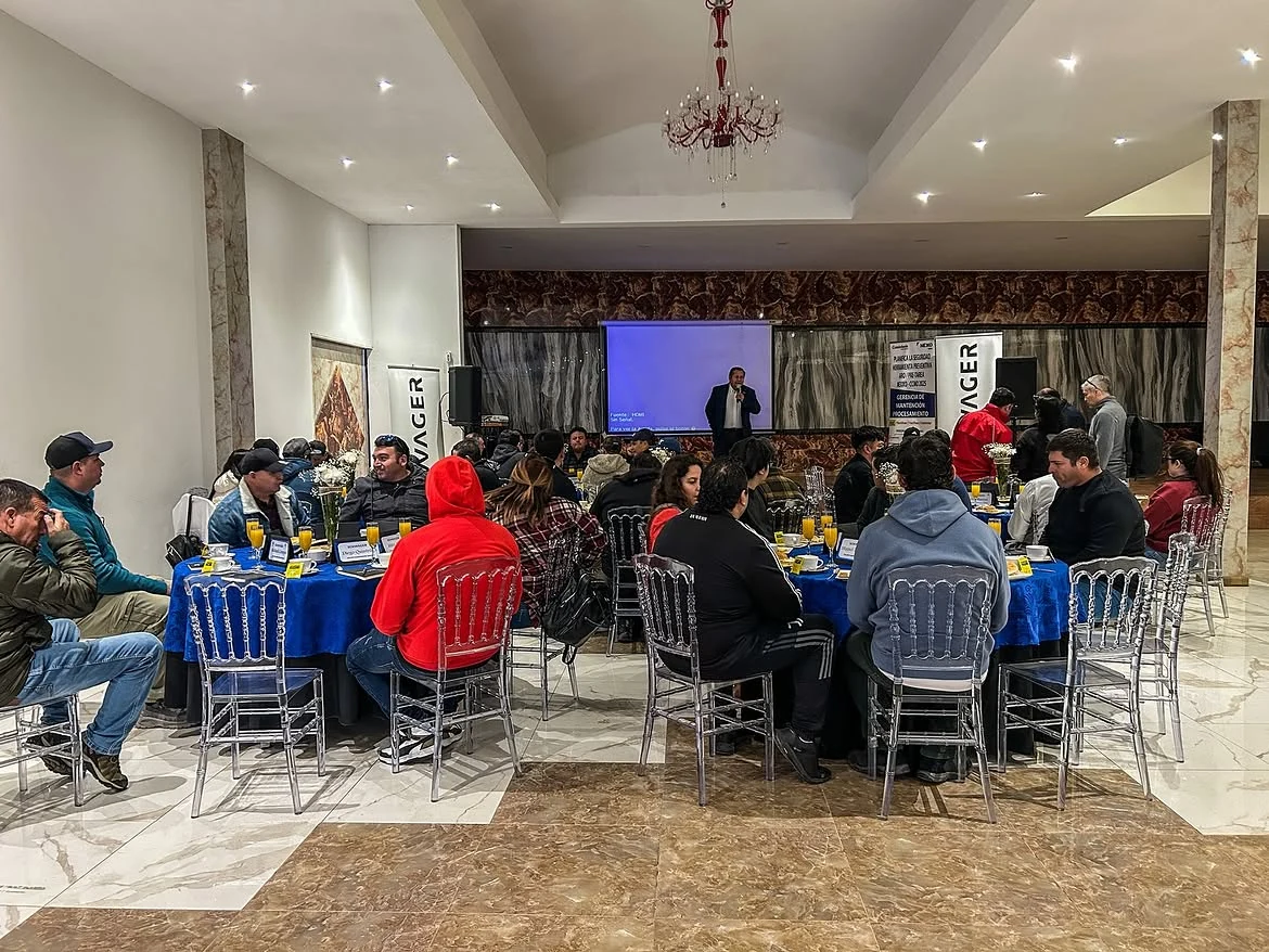 Evento empresarial con presentación y asistentes en mesas
