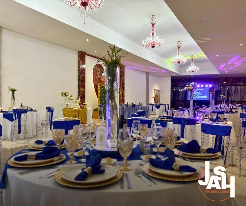 Salón montado con mesas, decoración e iluminación para celebración