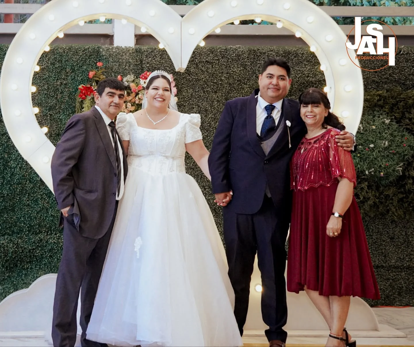 Novios junto a corazón LOVE iluminado en matrimonio